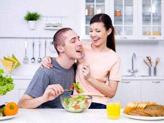 a woman nourishes a man with products to increase potency naturally